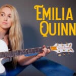 Emilia Quinn performing live on stage with her band.